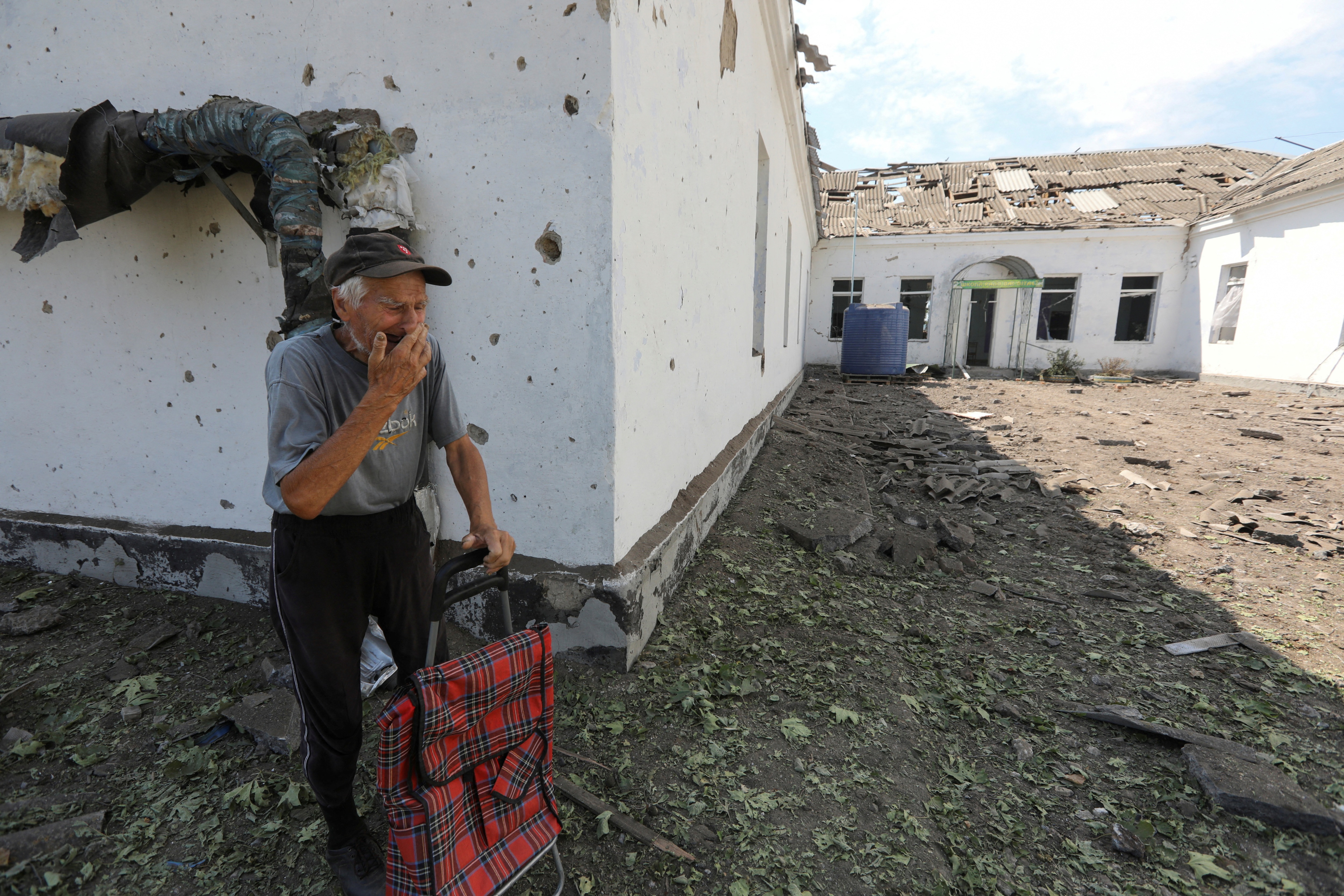 A local resident reacts near a school building damaged by a Russian missile strike in Mykolaiv, Ukraine. (REUTERS)