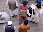 An Afghan money exchange dealer carries bundles of banknotes at an exchange market, following banks and markets reopening after the Taliban took over in Kabul, Afghanistan.&nbsp;