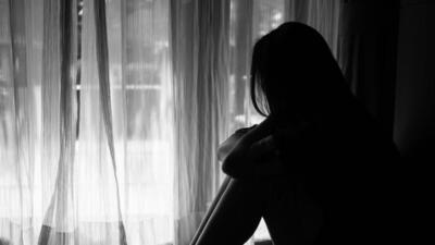 black and white of sad woman hug her knee and cry. Sad woman sitting alone in a empty room beside window or door (Siam - stock.adobe.com) black and white of sad woman hug her knee and cry. Sad woman sitting alone in a empty room beside window or door (Siam - stock.adobe.com)