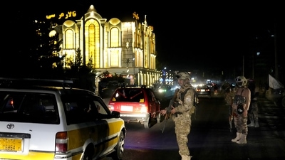 Taliban fighters stand guard at the site of an explosion in front of the Kabul International Cricket Stadium, in Kabul, Afghanistan. (AP)