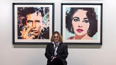 A photo of Johnny Depp with his artwork.