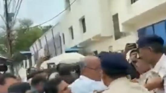 Digvijaya Singh seen holding a police officer's collar (ANI)