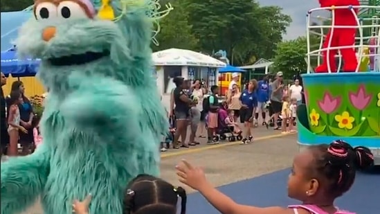 In this image from video provided by Jodi Brown, posted to Instagram on Saturday, July 16, 2022, a performer dressed as the character Rosita waves off Brown's daughter and another 6-year-old Black girl at the Sesame Place amusement park in Langhorne, Pa. (Jodi Brown via AP)