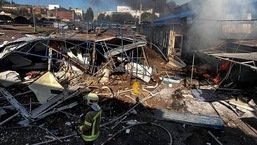 Um bombeiro apagando um incêndio em um mercado após bombardeio em Bakhmut, região de Donetsk, em meio à invasão russa da Ucrânia. 