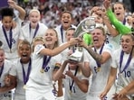 England's Leah Williamson, center left, and Millie Bright lift the trophy after winning the Women's Euro 2022 final soccer match