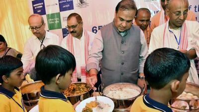 Assam chief minister Himanta Biswa Sarma serves lunch to students after the inauguration of the Centralised Kitchen of Akshaya Patra Foundation at Jorhat on Friday. (ANI PHOTO.)