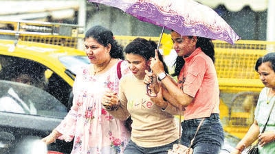 Mumbai, India - July 23, 2022: Three women share one umbrella while crossing the road in the rain at Prabhadevi, in Mumbai, India, on Saturday, July 23, 2022. (Photo by Satish Bate/ Hindustan Times) (Satish Bate/HT PHOTO)