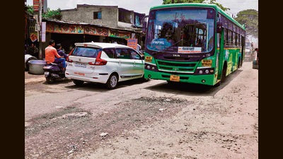 A PMPML bus plys through a pothole-ridden road at Upper Indiranagar. (Rahul Raut/HT PHOTO) A PMPML bus plys through a pothole-ridden road at Upper Indiranagar. (Rahul Raut/HT PHOTO)