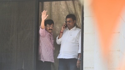 Shiv Sena leader Sanjay Raut waves at supporters as Enforcement Directorate officials conduct searches at his Mumbai residence. (Photo by Satish Bate) Shiv Sena leader Sanjay Raut waves at supporters as Enforcement Directorate officials conduct searches at his Mumbai residence. (Photo by Satish Bate)