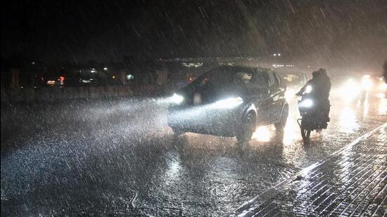 Vehicles ply on a road amid heavy rainfall, in Hyderabad on Sunday. (Agencies)