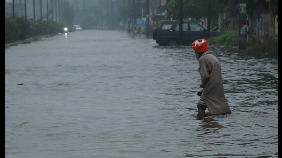 A pedestrian makes his way through knee-deep water after rain lashed Ludhiana on Sunday. (Harvinder Singh/HT) A pedestrian makes his way through knee-deep water after rain lashed Ludhiana on Sunday. (Harvinder Singh/HT)