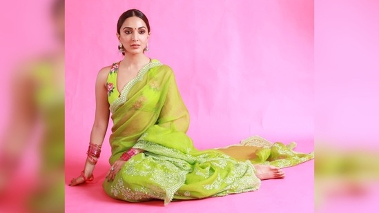 Kiara Advani proved once again that she can slay any look effortlessly as she strikes an elegant pose in this parrot green organza saree teamed with a floral printed sleeveless blouse.(Instagram/@kiaraaliaadvani)