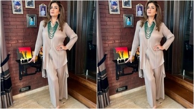 Raveena teamed an ivory white satin long shirt with a pair of trousers with wide legs. The co-ord set featured pleated fabric details all throughout. (Instagram/@officialraveenatandon)