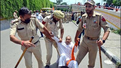 Cops detain a protesting daily wager in Jammu on Monday. (ANI Photo)