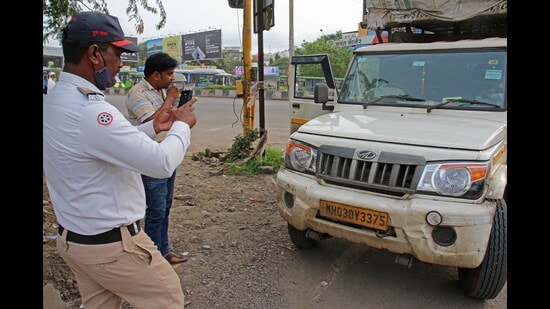 Pune traffic police official takes action against violators using e- chalan machine at Katraj chowk on Monday. (Ravindra Joshi/HT PHOTO)