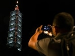 A person takes a picture of a pro-US sign displayed on a tower ahead of Speaker Nancy Pelosi's expected visit in Taipei, Taiwan,