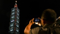Uma pessoa tira uma foto de um sinal pró-EUA exibido em uma torre antes da visita esperada da presidente Nancy Pelosi em Taipei, Taiwan,
