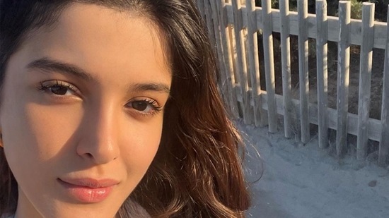 Shanya Kapoor paired her all-white short lace halter dress with nude sliders and a beige handbag.(Instagram/@shanayakapoor02)