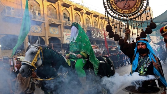 Shiite Muslims re-enact historical events of Ashura, a 10-day period commemorating the seventh century killing of Prophet Mohammed's grandson Imam Hussein, in Iraq's holy city of Karbala (Photo by Mohammed SAWAF / AFP)