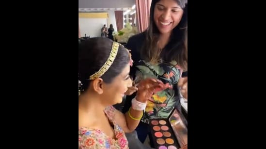 This makeup artist’s assistant hands a palette to her boss on her own wedding day.&nbsp;(Instagram/@ishakhannamakeup)