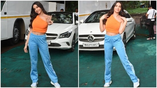 The paparazzi clicked Nora in the bay. The pictures show her doing fun poses for the camera. Coming to the design of her outfit, it features a pastel orange-coloured sleeveless top with a one-shoulder neckline, cropped hem flaunting the star's toned midriff, fitted silhouette, and gathered details on the side.(HT Photo/Varinder Chawla)