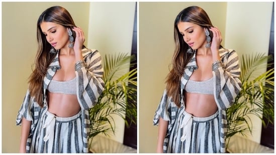 Tara chose a grey sports bra featuring a darker striped pattern. It also has a plunging U neckline to flaunt the star's decolletage and a midriff-baring cropped hem. Additionally, she layered a grey oversized collared shirt with dark grey vertical stripes, an open front, flared full sleeves, and drop shoulders on top of the sports bra.(Instagram)