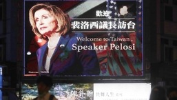 People walk past a billboard welcoming US House Speaker Nancy Pelosi, in Taipei, Taiwan.