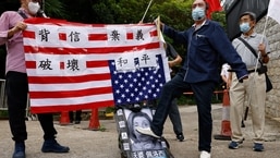Um apoiador pró-China pisa em uma foto desfigurada da presidente da Câmara dos Deputados dos EUA, Nancy Pelosi, durante um protesto contra sua visita a Taiwan.