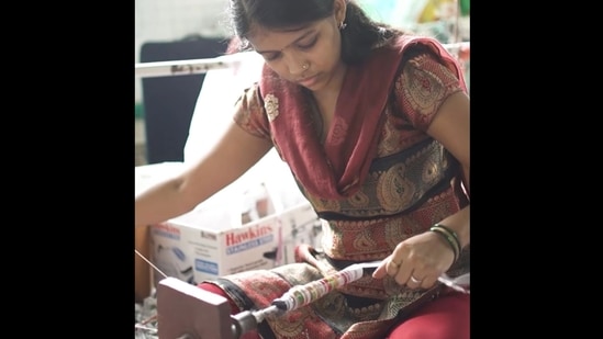 The image, taken from Instagram video, shows an artisan hand weaving plastic wrappers.(Instagram/@ecokaari)
