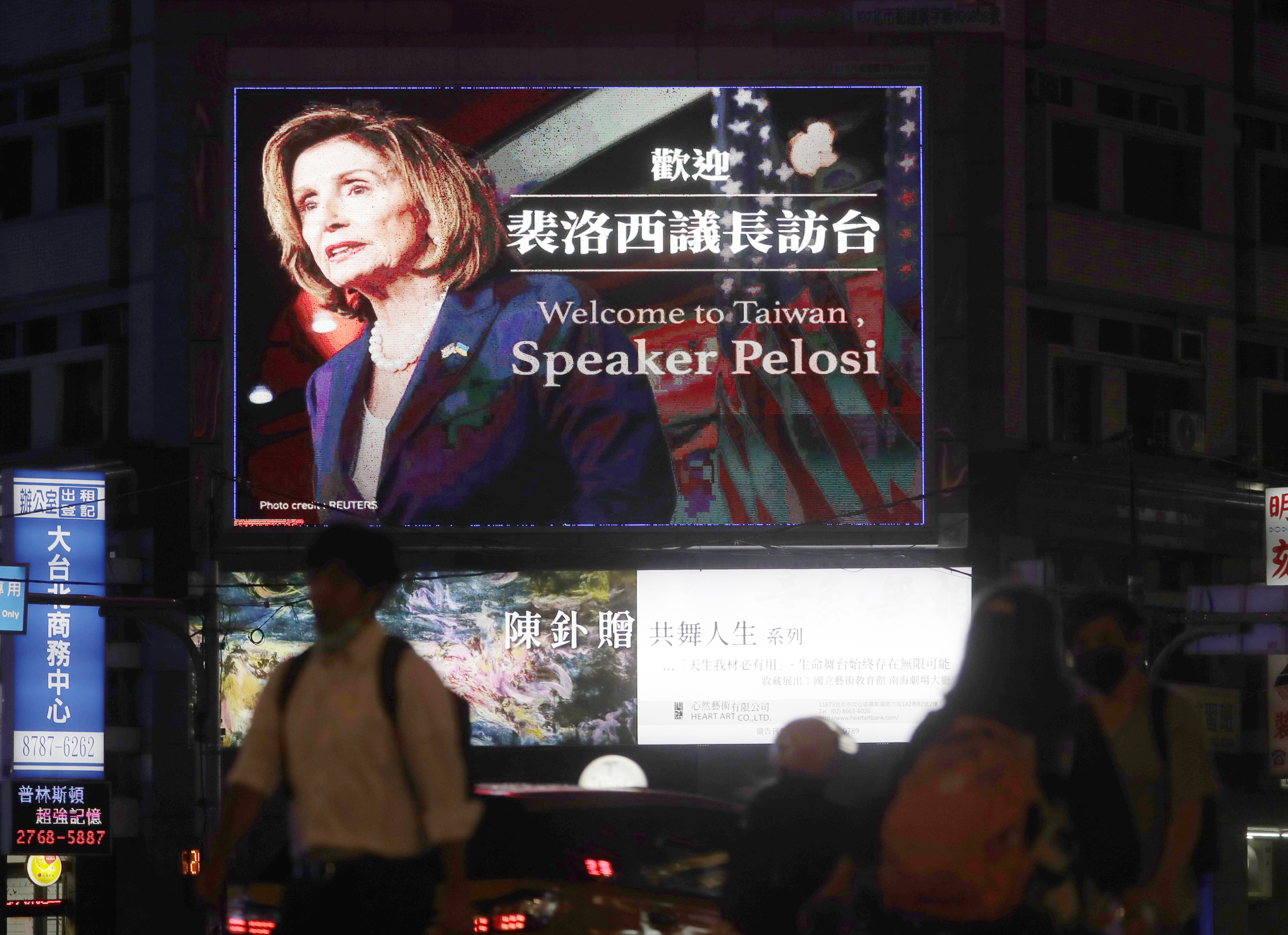 People walk past a billboard welcoming US House Speaker Nancy Pelosi, in Taipei, Taiwan. (AP)