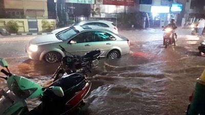 Vehicle ply on flooded street following heavy rainfall, in Bengaluru on Tuesday.&nbsp; (ANI)