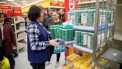 People wait as an employee restocks a shelf as people shop at a Walmart Supercentre in Toronto, Ontario, Canada. (REUTERS)