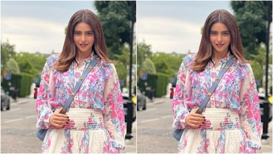 Aamna decked up in a white shirt that came with collars and full sleeves. The shirt featured intricate prints in shades of blue and pink in floral patterns.(Instagram/@aamnasharifofficial)