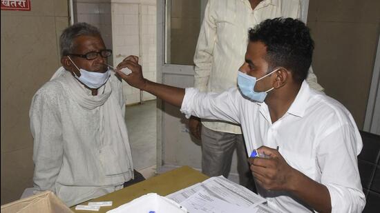 A healthcare worker collects a swab sample of man for Covid-19 test at the MMG Hospital in Ghaziabad on Thursday. (Sakib Ali/HT photo)