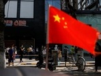 A China's flag flutters near people lining up to get tested at a makeshift nucleic acid testing site. (File image)