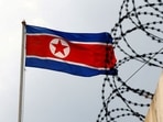 A North Korea flag flutters next to concertina wire at the North Korean embassy