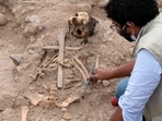 A Peruvian archaeologist works at a 1,000-year-old pre-Hispanic sanctuary located inside the capital's main zoo, where three colonial-era burials were found, in Lima, on August 4, 2022.(AFP)