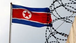 A North Korea flag flutters next to concertina wire at the North Korean embassy