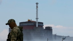 Um militar com uma bandeira russa em seu uniforme monta guarda perto da Usina Nuclear de Zaporizhzhia durante o conflito Ucrânia-Rússia fora da cidade de Enerhodar, controlada pela Rússia, na região de Zaporizhzhia.