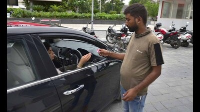 A staffer issuing a manual receipt at the Sarabha Nagar main market parking lot, which was taken over by the municipal corporation on Friday. (Gurpreet Singh/HT)