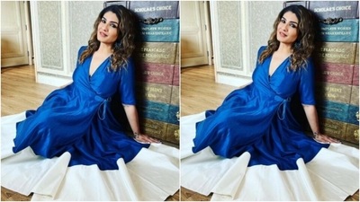 Raveena decked up in a satin blue long dress featuring a wrapped detail and a plunging neckline with a tie-around at the waist. (Instagram/@officialraveenatandon)