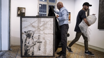 Koby Abergel, an Israeli art dealer, reveals a painting by the secretive British graffiti artist Banksy that was mysteriously transferred from the occupied West Bank to the Urban Gallery in Tel Aviv, Israel. The painting of a slingshot-toting rat once stood near Israel's separation barrier and was one of several works created in 2007 that protest Israel's decades-long occupation of territories the Palestinians want for a future state. (AP Photo/Oded Balilty) Koby Abergel, an Israeli art dealer, reveals a painting by the secretive British graffiti artist Banksy that was mysteriously transferred from the occupied West Bank to the Urban Gallery in Tel Aviv, Israel. The painting of a slingshot-toting rat once stood near Israel's separation barrier and was one of several works created in 2007 that protest Israel's decades-long occupation of territories the Palestinians want for a future state. (AP Photo/Oded Balilty)