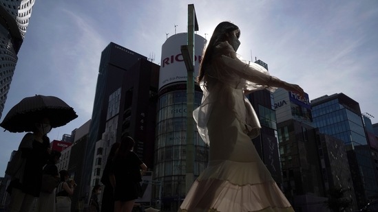 People wearing protective masks to help curb the spread of the coronavirus walk along a pedestrian crossing Monday, Aug. 1, 2022, in Tokyo.(AP)