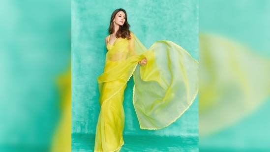 Vaani Kapoor teamed her solid yellow saree featuring a thin embroidered border with a sleeveless bralette blouse.(Instagram/@_vaanikapoor_)
