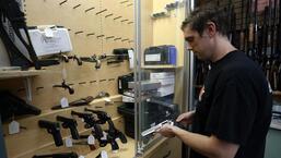 Um vendedor pega uma pistola Ruger GP100 Magnum 357 da vitrine da That Hunting Store em Ottawa, Canadá.  (AFP)