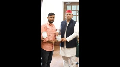 Pawan Kashyap receiving his membership receipt from SP national president Akhilesh Yadav in Lucknow. (HT photo)