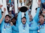 England's Eoin Morgan and teammates celebrate winning the world cup with the trophy