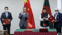 O ministro das Relações Exteriores da China, Wang Yi, de centro-esquerda, e seu colega de Bangladesh, AK Abdul Momen, aplaudem enquanto os dois países assinam acordos em Dhaka, Bangladesh, no domingo. 