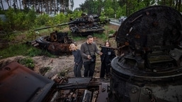 Moradores locais examinam tanques russos destruídos nos arredores de Kyiv.