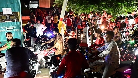 Bangladeshis queue at a gas station in Dhaka after government has increased fuel oil price. (Photo by AFP)